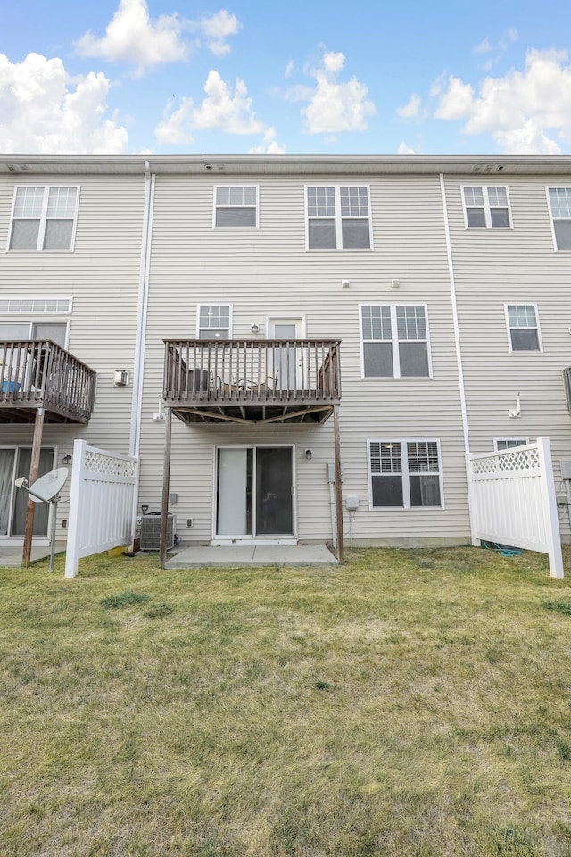 back of house featuring central AC unit, a patio area, and a lawn