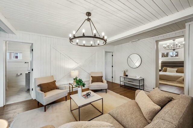 living room with wooden walls, dark hardwood / wood-style floors, and a notable chandelier