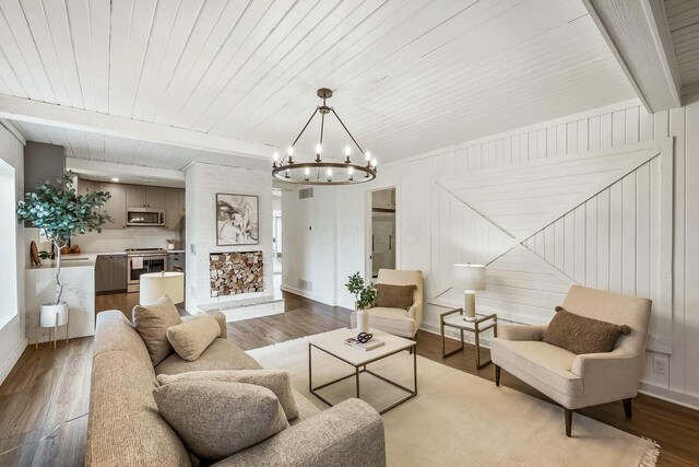 living room with hardwood / wood-style floors, beam ceiling, wooden ceiling, and a notable chandelier