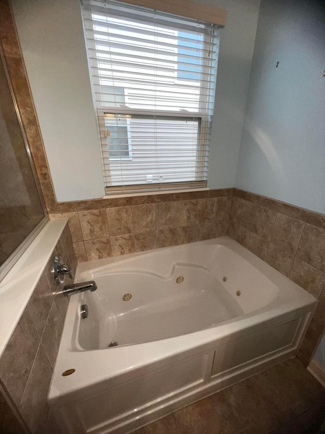 bathroom with tile patterned flooring and a bath