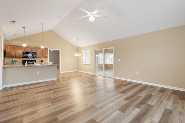 unfurnished living room with ceiling fan with notable chandelier, light hardwood / wood-style floors, and high vaulted ceiling