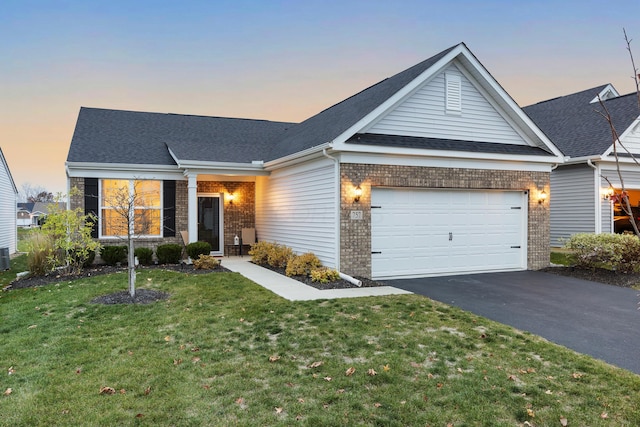 view of front of home with a yard and a garage