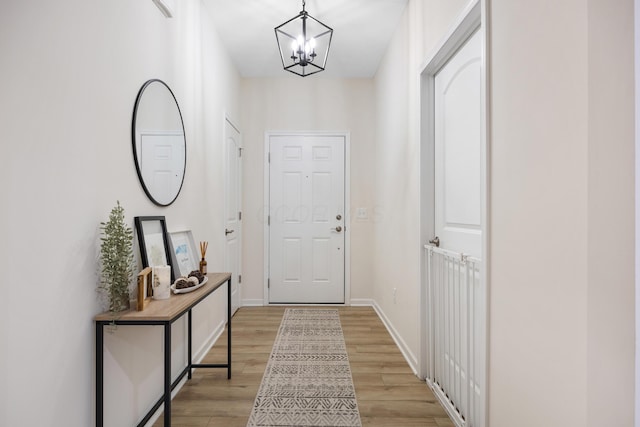 entryway with light wood-type flooring and an inviting chandelier