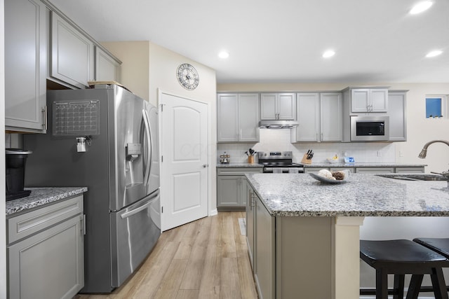 kitchen featuring gray cabinetry, sink, appliances with stainless steel finishes, and light hardwood / wood-style flooring