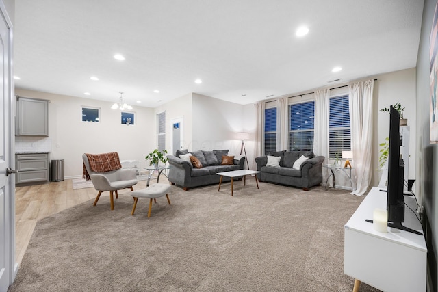 living room with light carpet and a chandelier