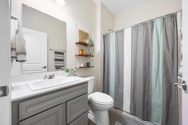 bathroom with a shower with shower curtain, vanity, and toilet