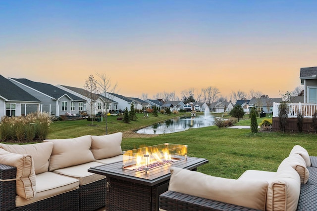 exterior space with a lawn, a fire pit, and a water view