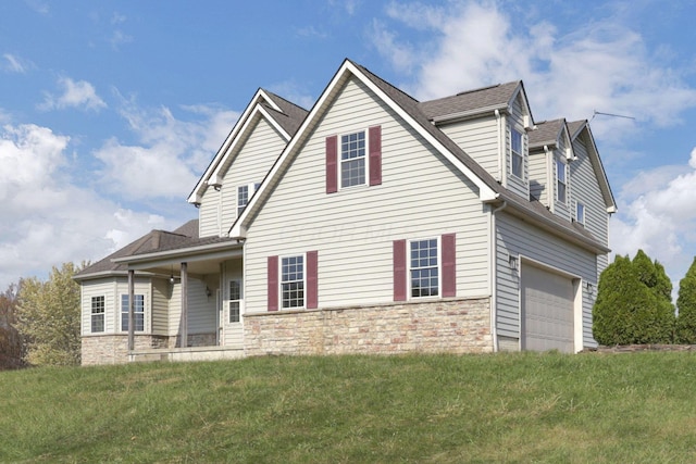 view of front of house with covered porch, a front yard, and a garage