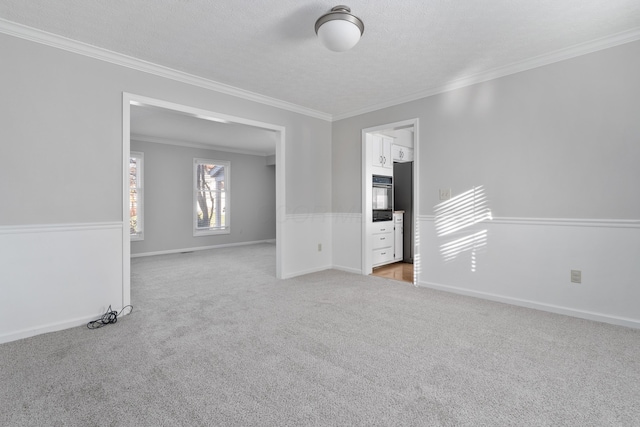 carpeted spare room with a textured ceiling and ornamental molding