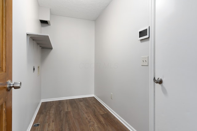 washroom with a textured ceiling, dark hardwood / wood-style flooring, and electric dryer hookup