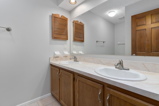 bathroom featuring tile patterned flooring, vanity, and a textured ceiling