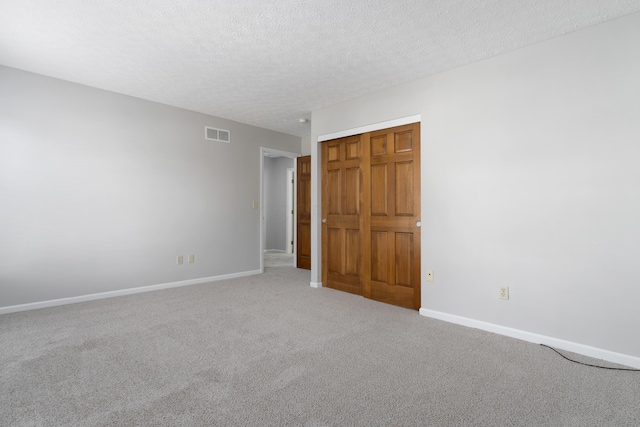 empty room featuring carpet and a textured ceiling