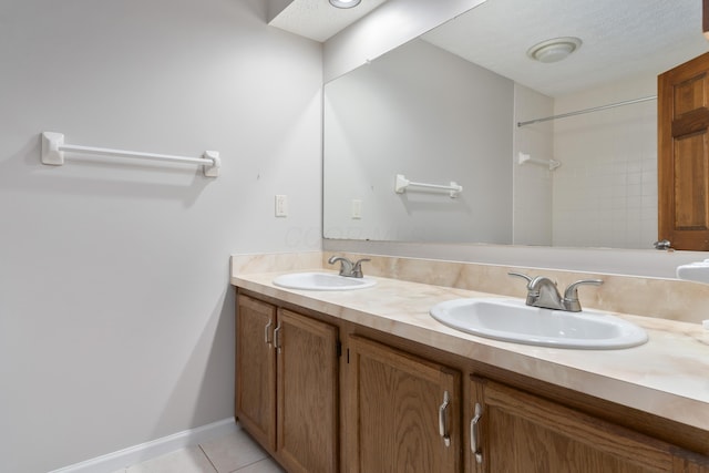 bathroom featuring tile patterned flooring, vanity, and a textured ceiling