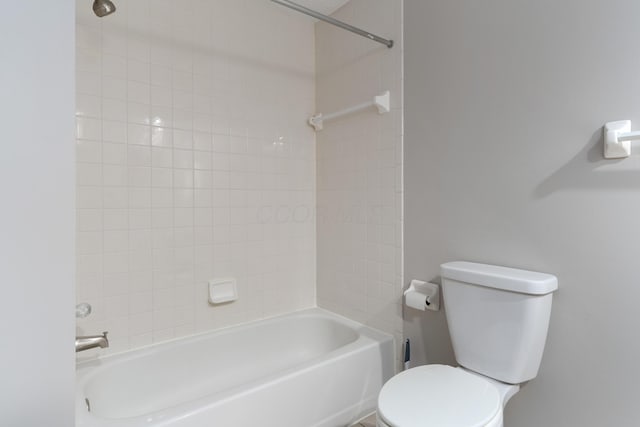 bathroom featuring tiled shower / bath combo and toilet