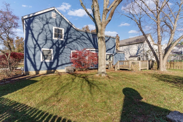 back of house featuring a wooden deck and a yard