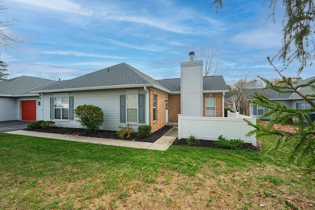 exterior space featuring a garage and a lawn