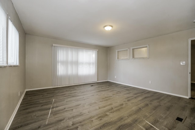 spare room with dark wood-type flooring