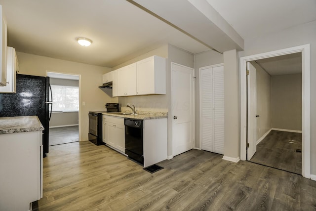 kitchen with hardwood / wood-style floors, sink, white cabinetry, and black appliances