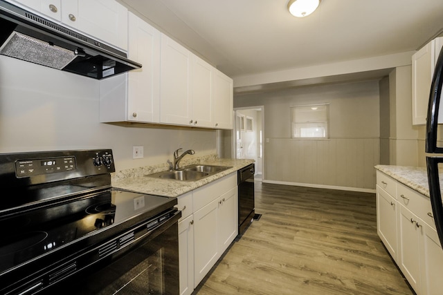 kitchen with light stone counters, sink, black appliances, light hardwood / wood-style flooring, and white cabinets