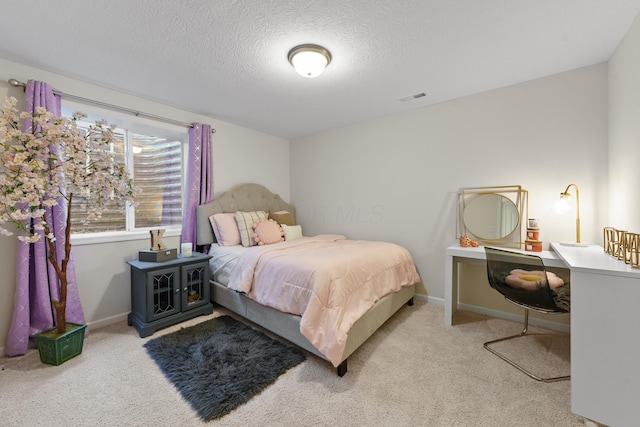 bedroom featuring a textured ceiling and light colored carpet