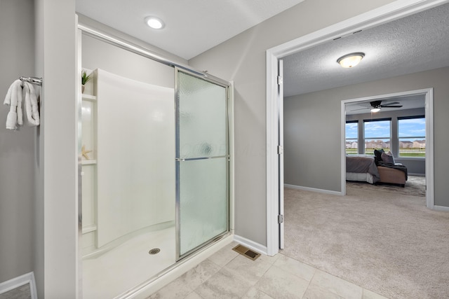 bathroom featuring a textured ceiling, an enclosed shower, and ceiling fan