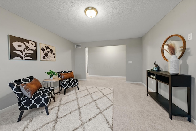 living area with a textured ceiling and carpet floors