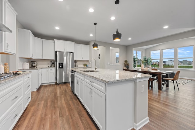 kitchen with white cabinetry, sink, an island with sink, and stainless steel appliances