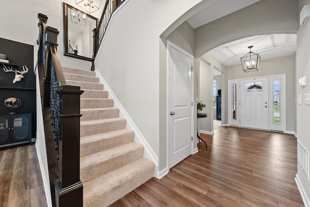 foyer featuring dark wood-type flooring and an inviting chandelier