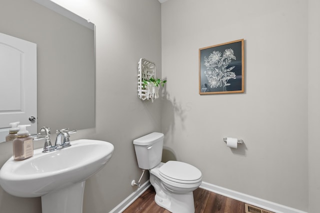 bathroom featuring hardwood / wood-style floors, toilet, and sink