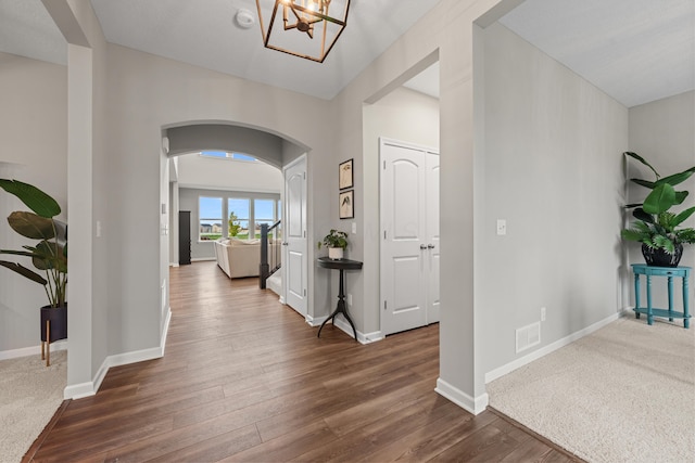 hallway featuring dark hardwood / wood-style floors and a chandelier