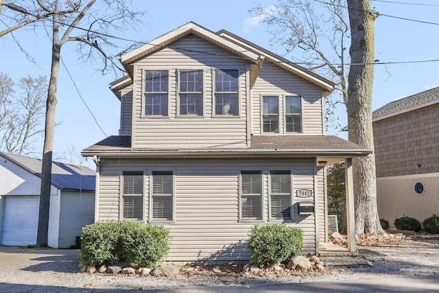 view of front property featuring a garage and an outbuilding