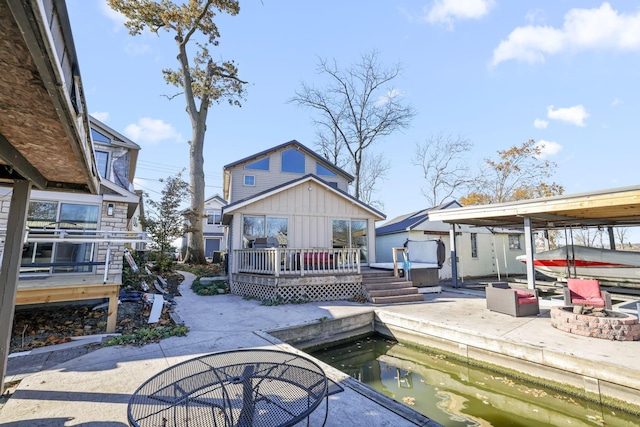 back of house featuring a deck, a jacuzzi, and an outdoor fire pit