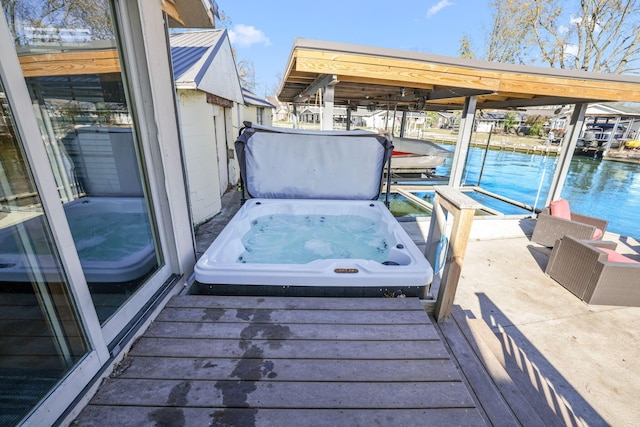 view of dock featuring an outdoor hot tub and a water view