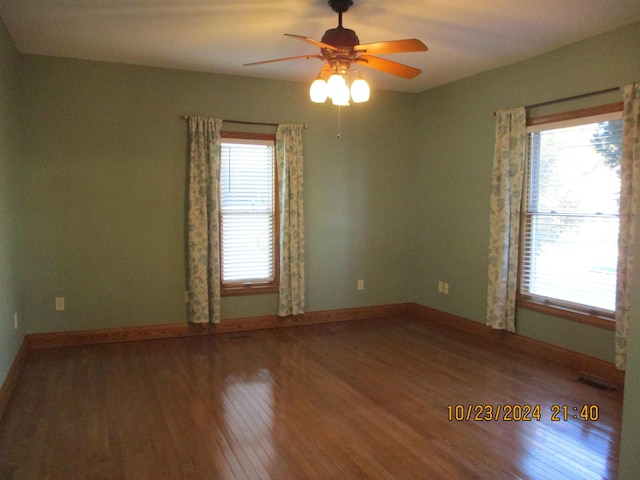 unfurnished room with hardwood / wood-style floors, ceiling fan, and a healthy amount of sunlight