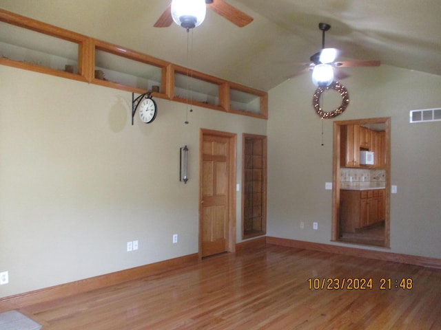 unfurnished living room featuring ceiling fan, light wood-type flooring, and vaulted ceiling