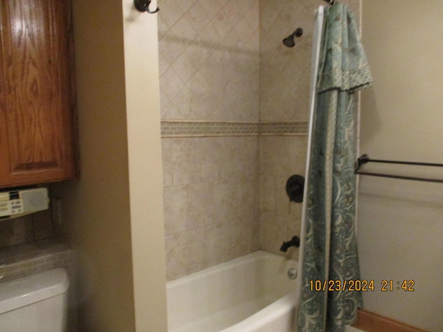 bathroom featuring toilet and shower / bathtub combination with curtain