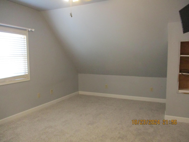 bonus room with light colored carpet and lofted ceiling