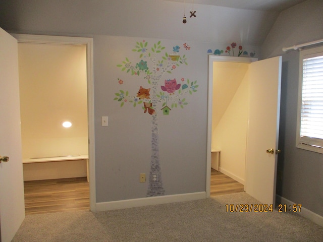 empty room featuring lofted ceiling and light hardwood / wood-style flooring