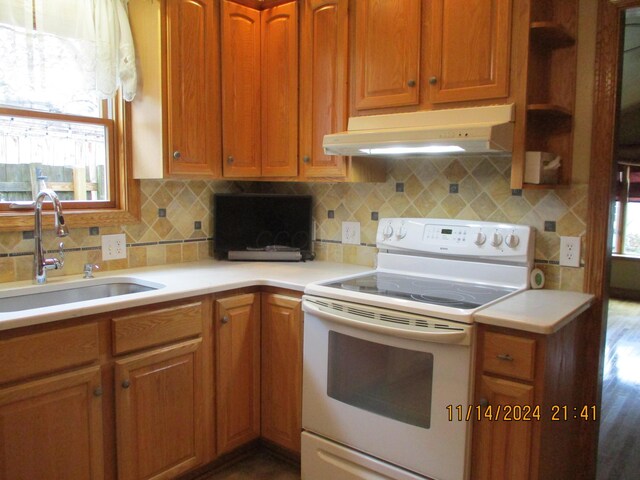 kitchen featuring decorative backsplash, white electric range, dark wood-type flooring, and sink