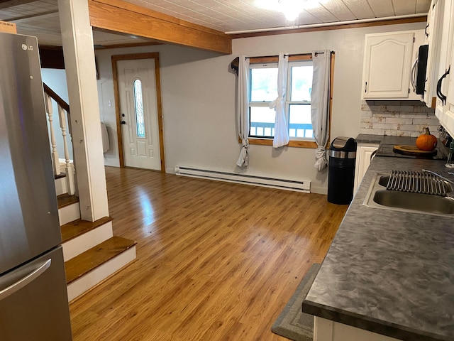 kitchen featuring baseboard heating, stainless steel refrigerator, white cabinetry, and light wood-type flooring