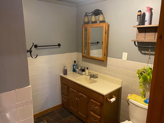 bathroom with vanity, tile walls, and toilet