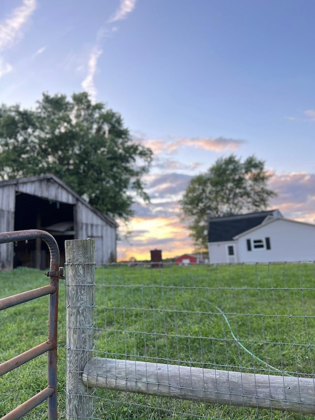 yard at dusk featuring an outbuilding