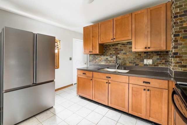 kitchen with backsplash, black range with electric stovetop, sink, light tile patterned flooring, and stainless steel refrigerator