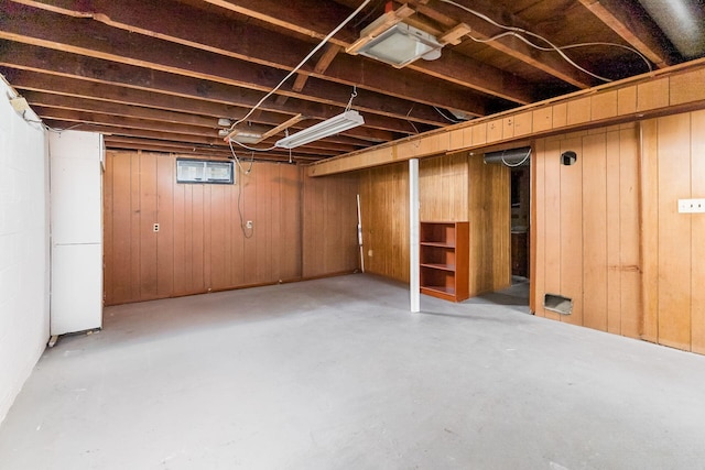 basement featuring wooden walls