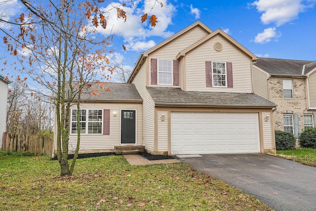 view of property featuring a garage and a front lawn