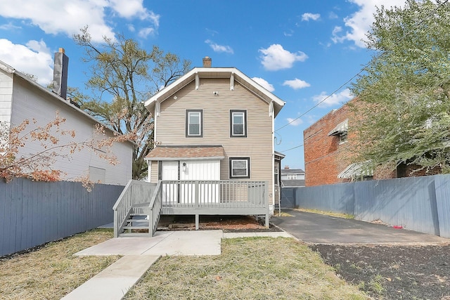 back of property with a yard and a wooden deck