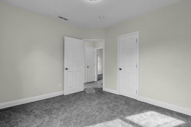 unfurnished bedroom with dark colored carpet