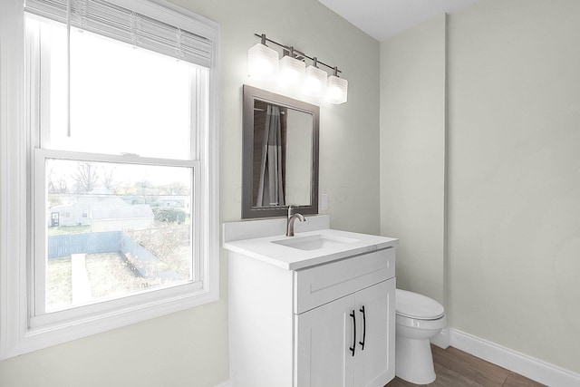 bathroom with wood-type flooring, vanity, and toilet