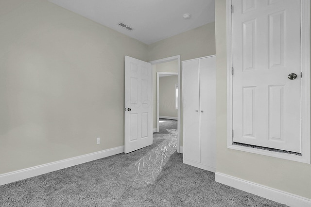 unfurnished bedroom featuring dark carpet