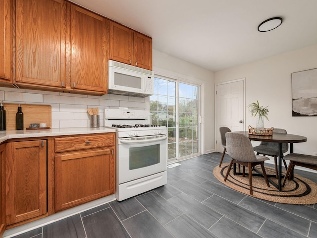 kitchen featuring decorative backsplash and white appliances